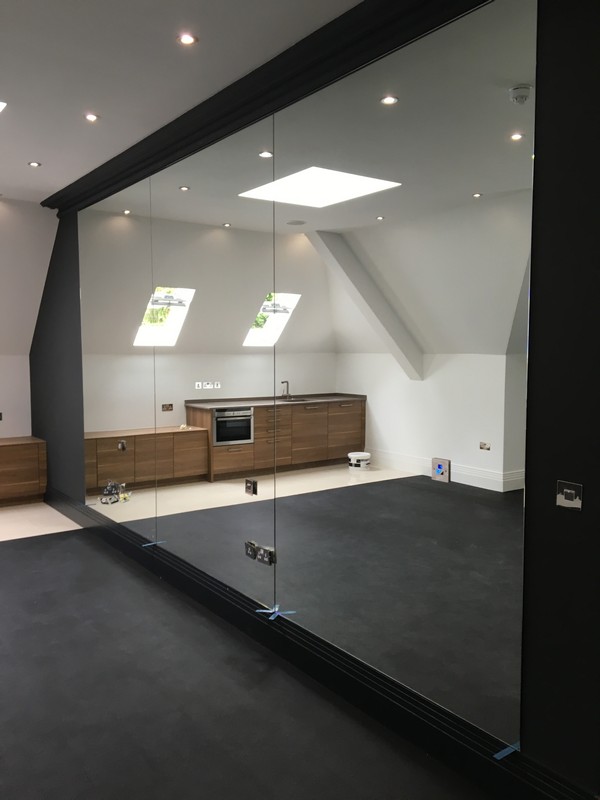 Frameless glass partition in loft conversion by Windsor glaziers